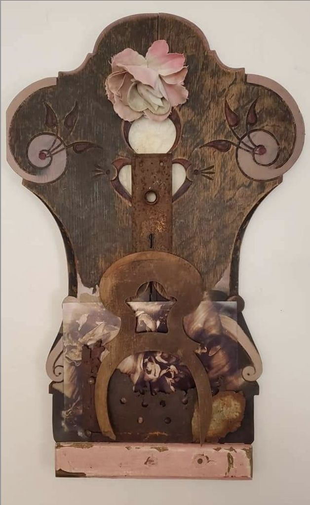 assemblage art with carvings, appears to be a wooden headstock